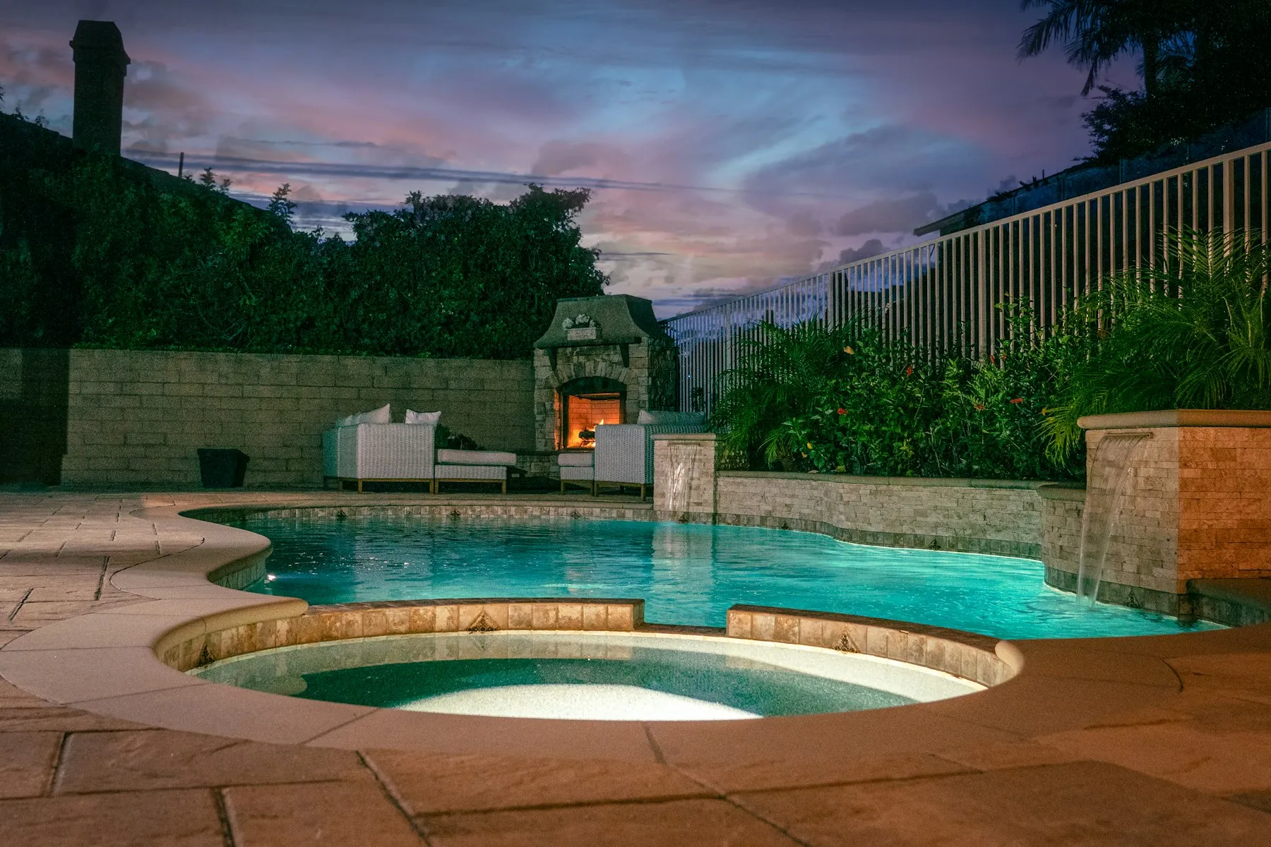 Backyard pool and spa glowing at dusk